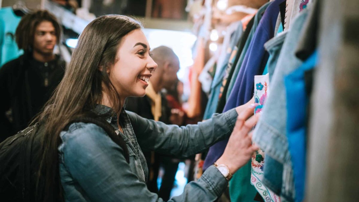 Happy girl shopping at clothes shop.