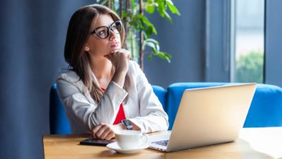 Woman on her laptop thinking to herself.