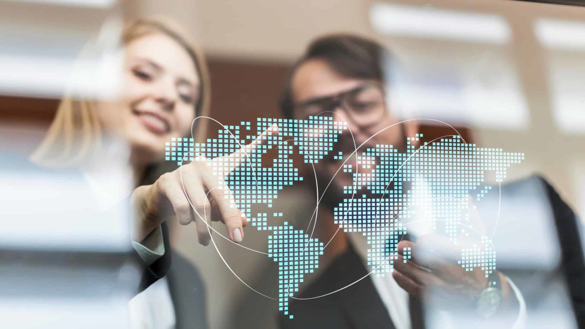 Two people work with a digital map of the world, planning their logistics on a global scale.