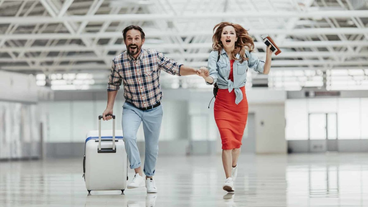 A couple are running late for their flight as they rush to the gate.