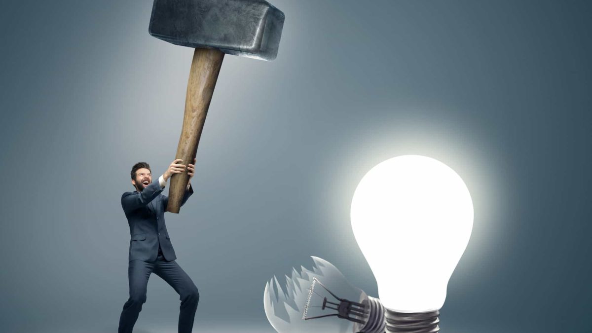 A man smashes light bulbs with a huge hammer.