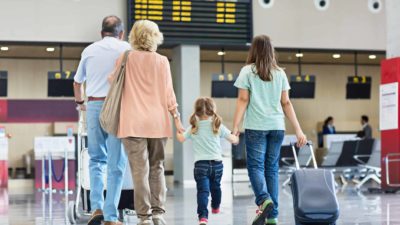 Family going into a airport check-in line.