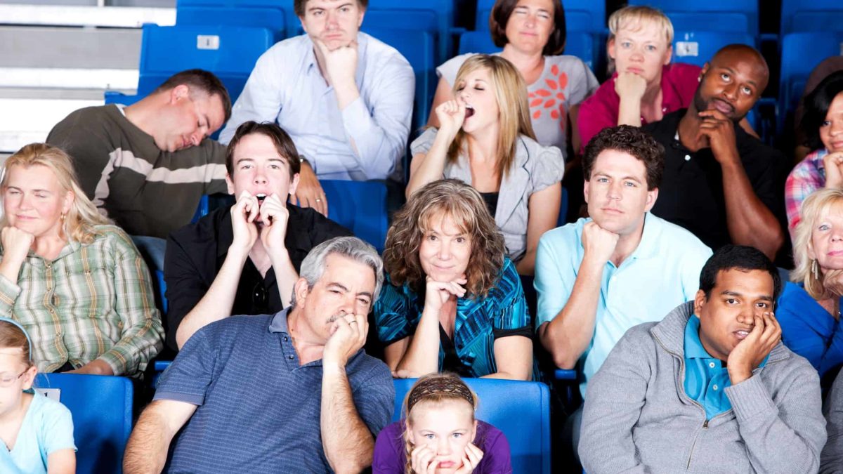 A sports crowd look bored and unimpressed.