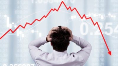 A man with his back to the camera holds his hands to his head as he looks to a jagged red line trending sharply downward representing the ASX tech share sell-off today