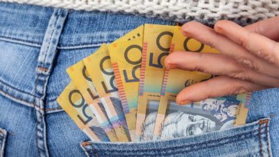 $50 dollar Australian notes in the back pocket of jeans representing dividends.