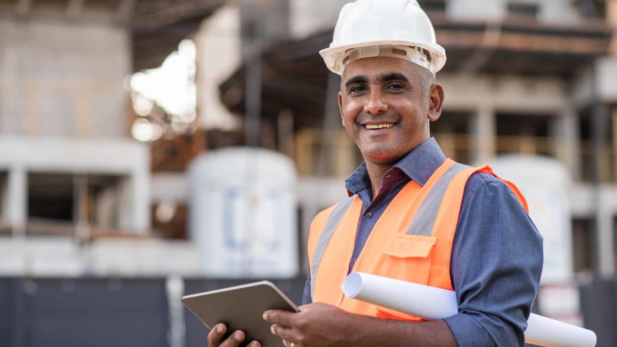 Engineer smiling with a tablet in his hand.
