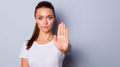 Woman with her hand out, symbolising a trading halt.