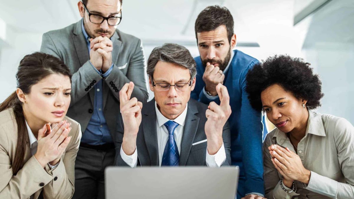 A group of executives crowd around a laptop hoping and praying with their fingers crossed that the Lynas share price will go up