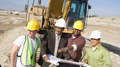 Inspectors and workers discussing with each other at a mine site.