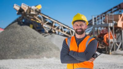 Happy miner with his arms folded.