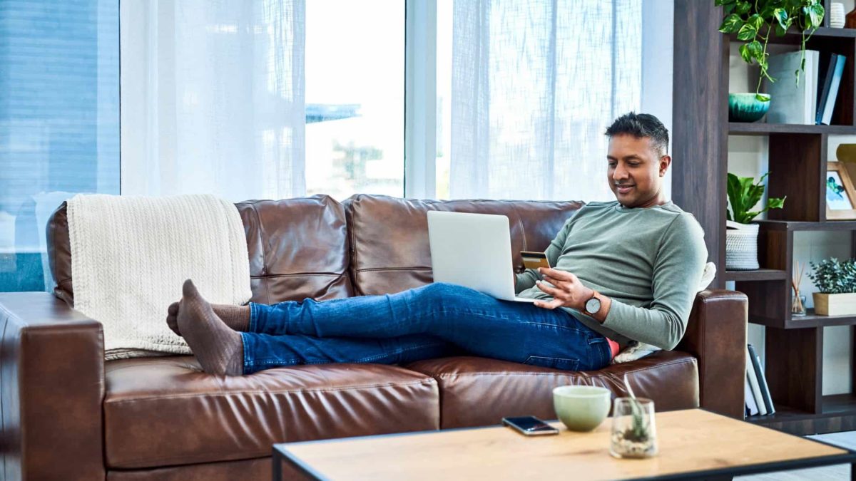 Happy man doing online shopping.