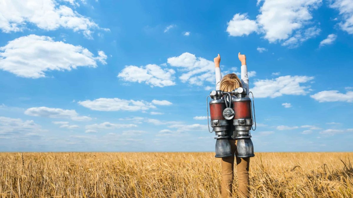 A boy is about to rocket from a copper-coloured field of hay into the sky.