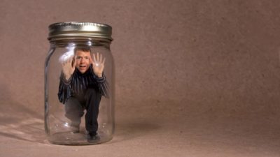 A man is trapped inside a glass jar.