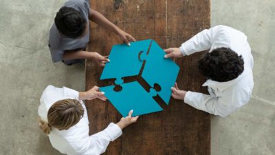 Three people connect their puzzle pieces together to make a triple threat.