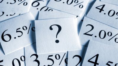 Pieces of paper with percetage rates on them and a question mark.