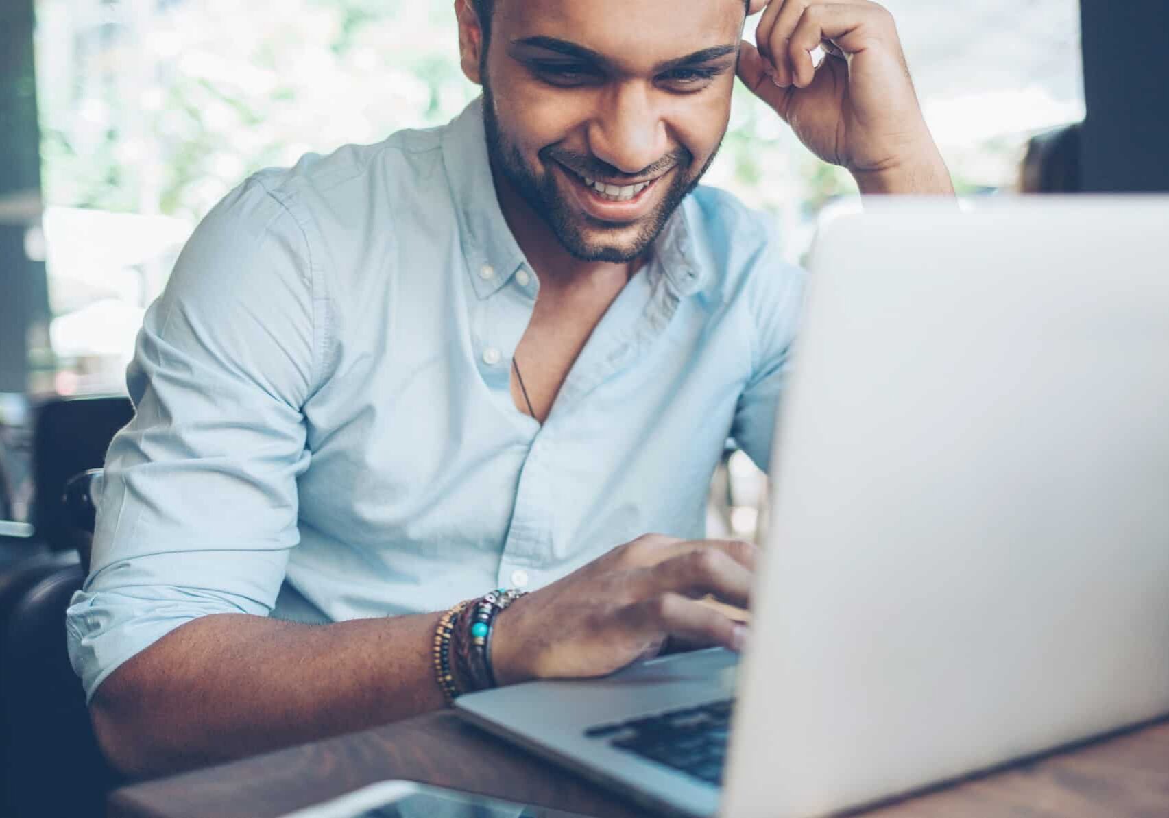 man using laptop happy at rising share price